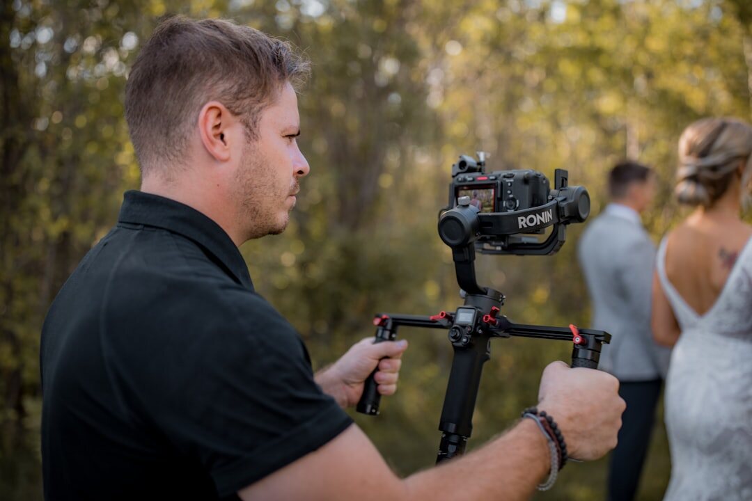 Camera operator filming a live outdoor event on a gimbal rig